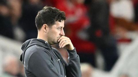 Ryan Mason holds his hand over his mouth as he watches from the dugout