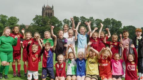 Kids in football kits celebrating
