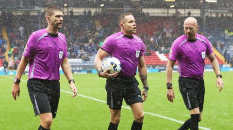 Referee Steve Martin and Assistant referees Mark Dwyer and Johnathon Bickerdike walk off the pitch