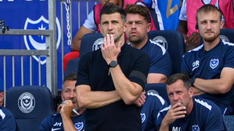 John Mousinho looks on from the touchline at Fratton Park