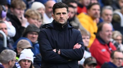 John Mousinho with arms folded