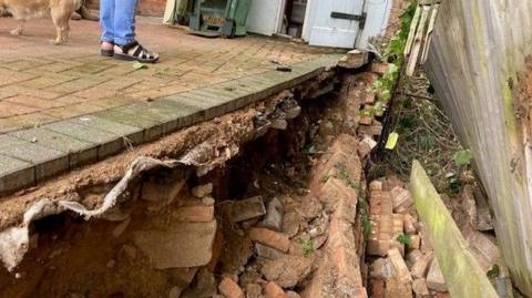 A hole left by the collapsed wall at the property