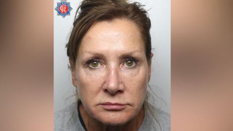 Pamela Gwinnett's mugshot. She has brown hair piled up on her head and is wearing a grey sweatshirt