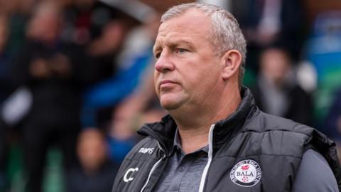 Colin Caton watches a game from the sidelines