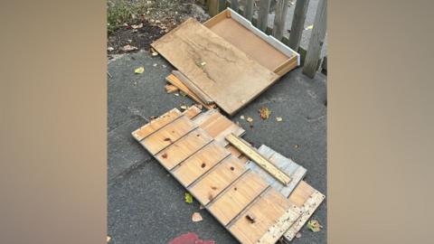 A large wooden box broken open in a playground.