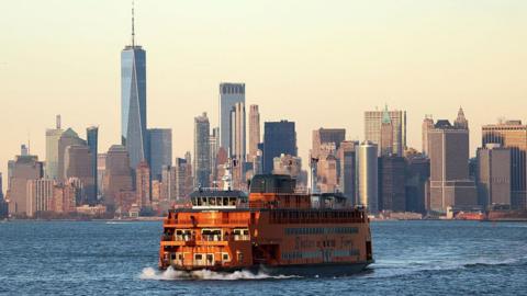 The popular Staten Island Ferry is pictured with New York City in the backdrop