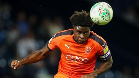 Luton Town player Pelly-Ruddock Mpanzu heads the ball