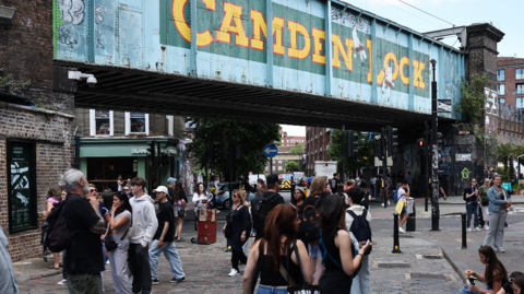 People walking near the famous sign for Camden Lock in north London