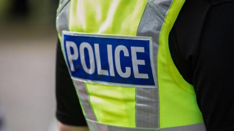 The back of a police officer wearing a Hi Vis  jacket