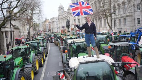 A farmer's daughter from Kent stands on a tractor parked on Whitehall, during a protest by farmers in Westminster against the changes to inheritance tax announced in October's Budget 