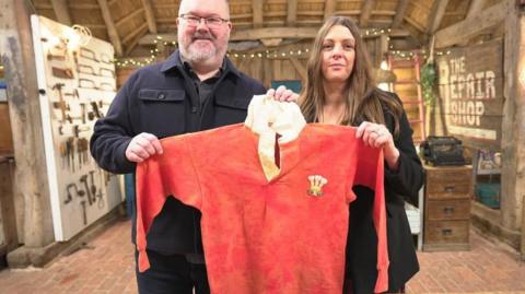 Lloyd Richards and Karen Richards with the damaged Wales shirt Lloyd's father Bryan played in 