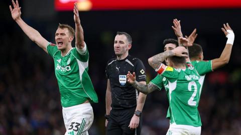 Kieran Trippier, Dan Burn and Sandro Tonali of Newcastle United react after referee Chris Kavanagh failed to award a penalty against Aston Villa