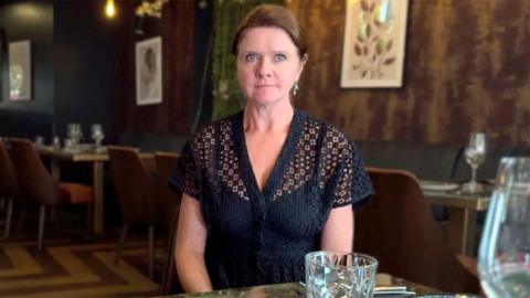 Kate Nicholls sat in a restaurant in a black top