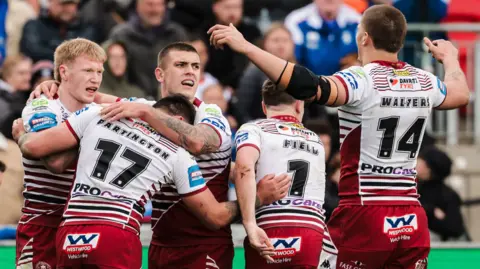 Wigan players celebrate Zach Eckersley's second try