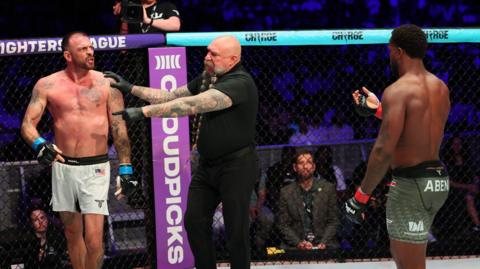 Mike Beltran holds back Joe Schilling as Donegi Abena holds up his hand