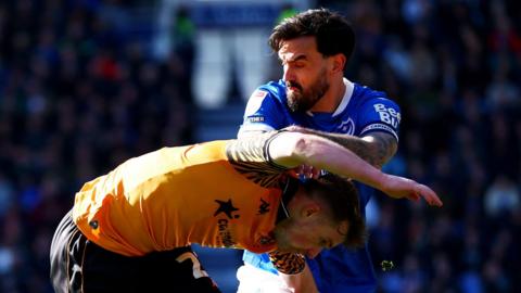 Portsmouth's Marlon Pack and Hull City's Joe Gelhardt tangle while competing for the ball