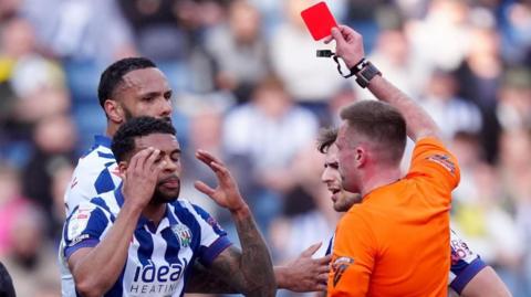 Darnell Furlong puts his hands up to his face after getting sent off