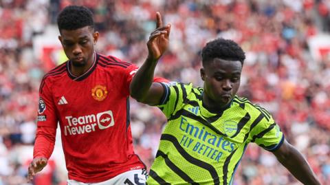 Bukayo Saka and Amad Diallo battle for the ball