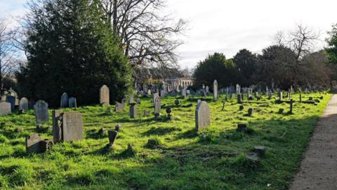 A cemetery full of graves with lots of grass.