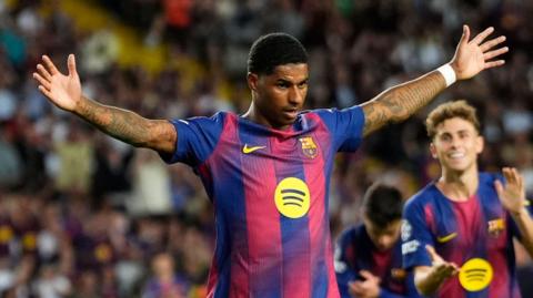 Barcelona striker Marcus Rashford celebrates with his arms spread wide
