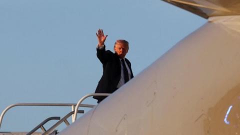 President Donald Trump waves as he boards Air Force One