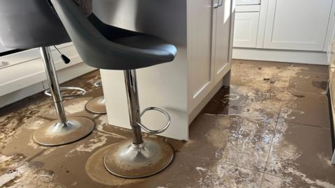 Water damaged floor in the kitchen of Jane and Jimmy West's home  after recent flooding. 