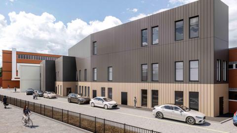 A design image of a modern three‑storey building with a metallic façade faces a street with parked cars, pedestrians and a passing cyclist.