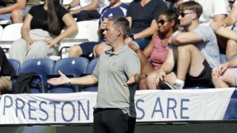 Marti Cifuentes on the touchline with his arms out wide.
