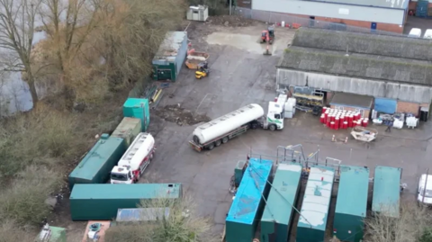 A bird's eye view of tankers and lorries in a depot.