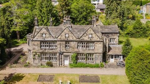A large 17th century manor brick house. It was large grounds with lawns, trees and shrubs.