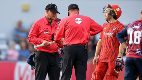 The match umpire removes Lancashire Lightning' Phil Salt's bat due to it being too big during the Vitality T20 Blast North Group match between Northants Steelbacks and Lancashire Lightning