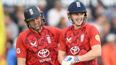 England's Jos Buttler (left) and Harry Brook (right) smile while batting together against West Indies in a T20