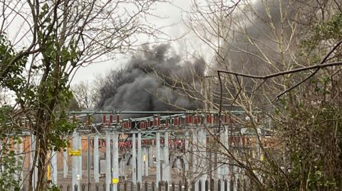 Grey smoke seen behind an electrical substation