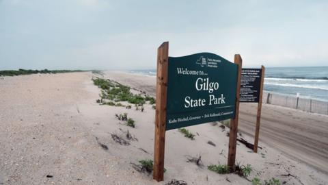 A sign on a beach reads: Welcome to Gilgo State Park