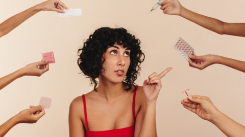 A woman sits looking at different contraceptive choices, including pills and condoms