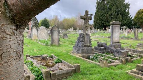 A graveyard, showing lots of older-style headstones. 