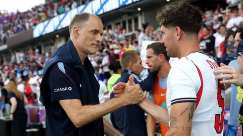 Thomas Tuchel, Manager of England, shakes hands with John Stones