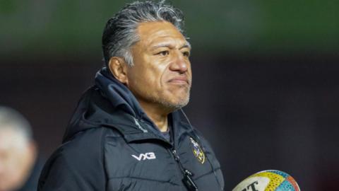 Dragons head coach Filo Tiatia holding rugby balls