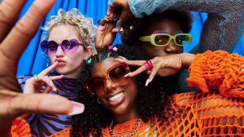 Having fun and standing in front of a photo booth style blue curtain. stock image