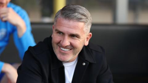 Ryan Lowe smiling on the touchline
