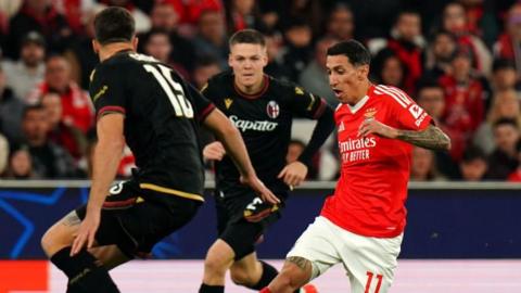 Angel Di Maria of S.L Benfica runs with the ball whilst under pressure from Nicolo Casale of Bologna