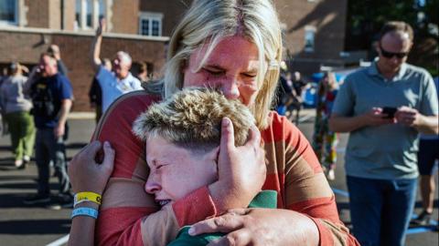 Parent hugs child after US school shooting