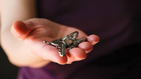 A stock image of someone holding a set of house keys.