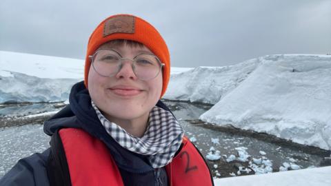 A woman standing outside in Port Lockroy, Antarctica 