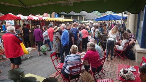 A group of people walking around a market