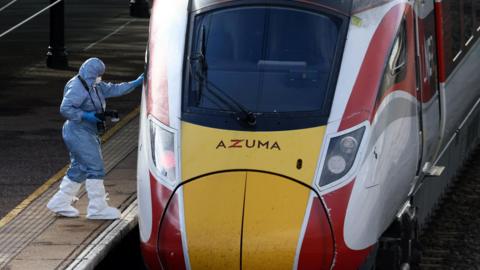 A forensic officer inspects the London North Eastern Railway (LNER) train where a series of stabbings took place, at a platform at Huntingdon Station.