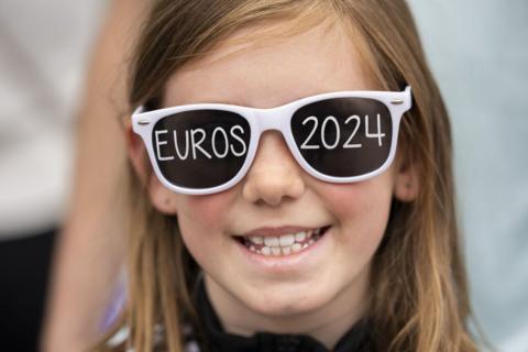 Girl wearing Euros themed sunglasses.