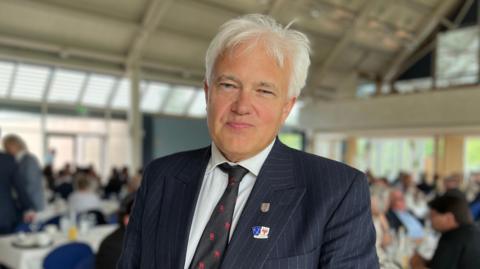 A picture of The Bailiff of Jersey, Robert MacRae. He is wearing a suit and he has grey hair.