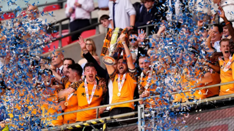 Hull City players lift a cup at Wembley as confetti is thrown 