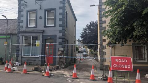 The fenced-off area and the road closure sign at Kirkgate, Cockermouth